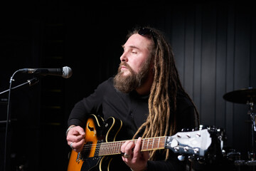 Obraz premium Guitarist man plays an electric guitar Close-up at studio