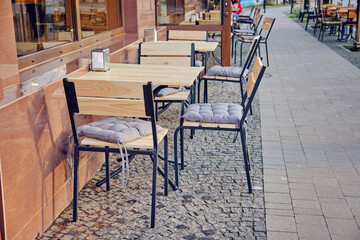 Fototapeta na wymiar Outdoor street cafe tables ready for service.