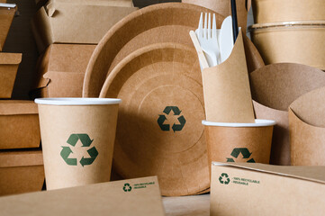 Eco-friendly disposable tableware made of biodegradable paper with a recycling sign. Close-up,...