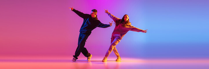 Synchronized movements. Young expressive hip-hop dancers dancing in neon. Concept of dance, youth,...