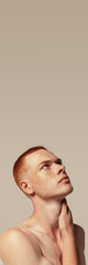 Naklejka premium Handsome young red-haired man posing isolated over grey studio background. Male natural beauty. Concept of men's health, posing, beauty, body and skin care.