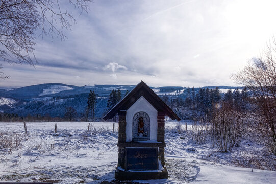 Blick auf einen Bildstock und das Hochsauerland im Winter