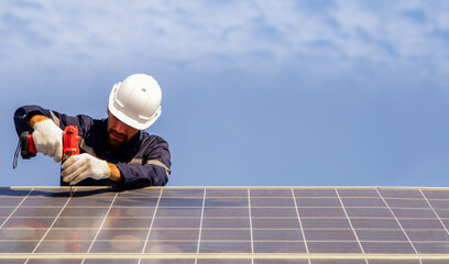 Male technician installing solar panel using electric drill securing solar system installation structure outdoors working outdoors : concept of renewable energy construction