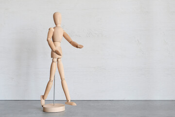 Wooden mannequin, male demonstrates with his hands. Copyspace.