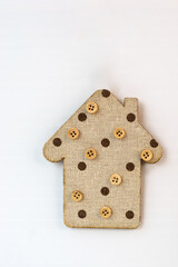decorative toy house with buttons made by hand on a light background