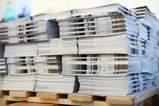 Stack of magazines placed on wooden pallet in printing office
