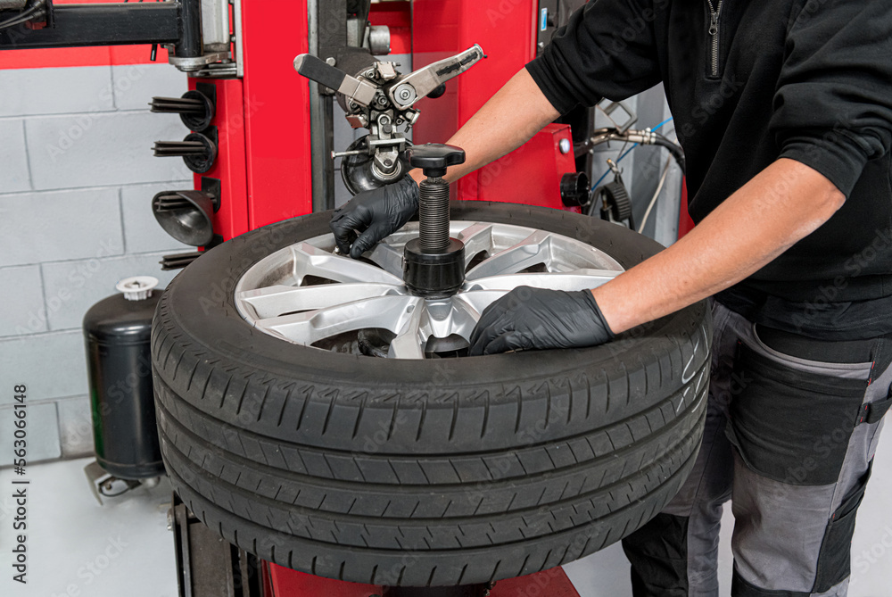 Wall mural Male operator dismantling tire during work