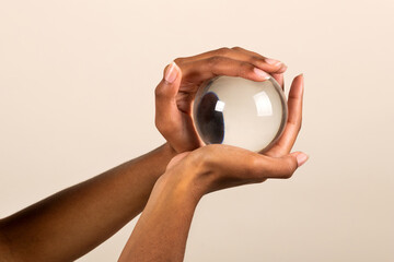 Fototapeta na wymiar Crop black woman holding transparent glass sphere