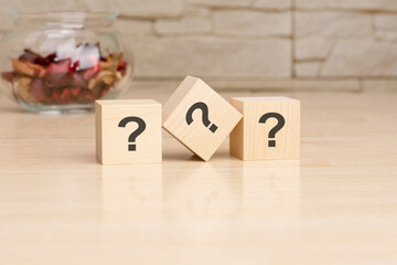 three wooden blocks with questions, top view on grey background