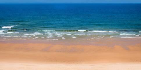 Fototapeta na wymiar blue sea with foaming waves and sandy beach. maritime Background