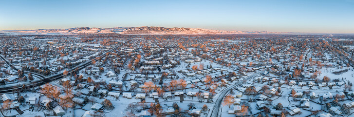 winter sunrise over residential area of Fort Collins and Rocky Mountains foothills in northern Colorado, aerial panorama view