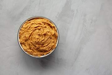 Yummy Organic Peanut Butter in a Bowl, top view. Flat lay, overhead, from above. Copy space.
