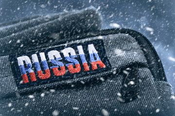 Khaki military backpack with patch with inscription Russia during heavy snowfall.Concept Russian...