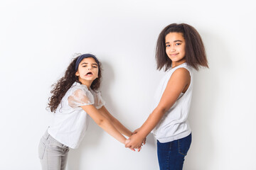 Adorable 9 years child girl on studio white background with her sister