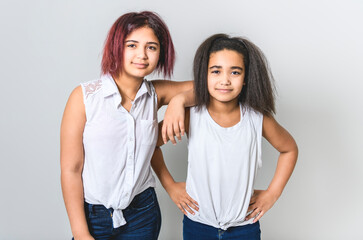 portrait of two beautiful sister over studio background