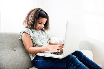portrait of cute child using laptop on sofa