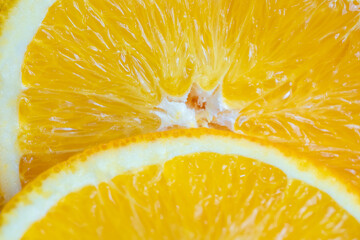 Slice of split orange fruit in an appetizing-looking macro photo.