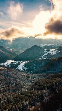 Vertical Hyper lapse of fast clouds above winter forest nature in sunny mountains landscape social media video