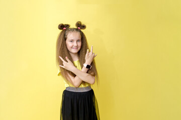 Cool cute girl with a trendy hairstyle in a yellow top on a yellow background with bright emotions