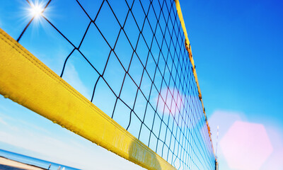 Part of volleyball net mounted on coastline on sandy beach