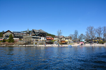 Fototapeta na wymiar On the Titisee overlooking the village of Neustadt and blue sky