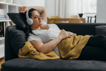 Overweight adult woman rests on the sofa