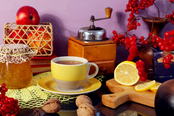  Winter still life: a yellow mug with tea, bouquets of viburnum, apples, an old coffee grinder, lemons on a pastel background, reflection from objects