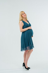A beautiful pregnant girl poses in the studio