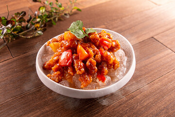 Iced Sweet and Sour Pork served dish isolated on wooden table top view of Hong Kong food
