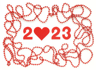 Red felt numbers 2023 on white background. Zero in the shape of a heart. Red beads around. Flat lay for Valentine's Day.