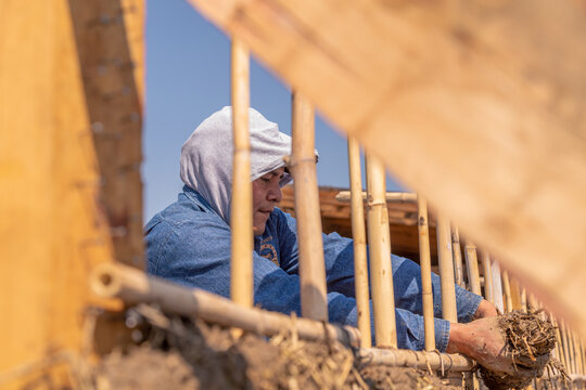 a person building with mud bioconstruction permaculture