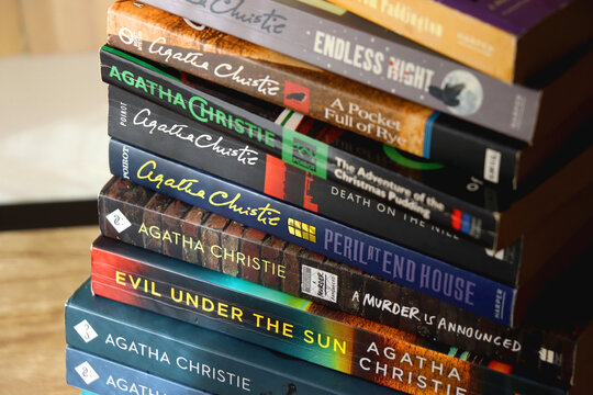 Split, Croatia - January 15, 2023: Stack of murder mystery books by famous author Agatha Christie. Bookshelf in the background. Selective focus.