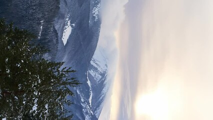 Clouds moving over the mountains during twilight in winter landscape. Vertical video - Powered by Adobe
