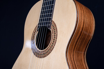 Classical guitar top isolated on black background with a beautiful mosaic rosette, view from the top side. Beautiful Brazilian wood - Pau Ferro on the back and spruce on the top. 