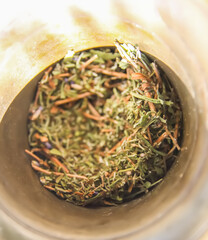 Obraz premium Medicinal herbs and flowers in a cooper mortar.