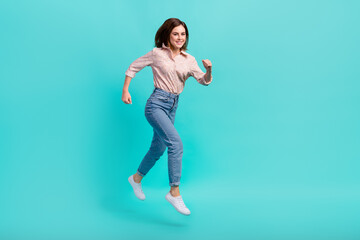 Fototapeta na wymiar Full length photo of adorable sweet lady wear pink shirt jumping high running fast isolated turquoise color background