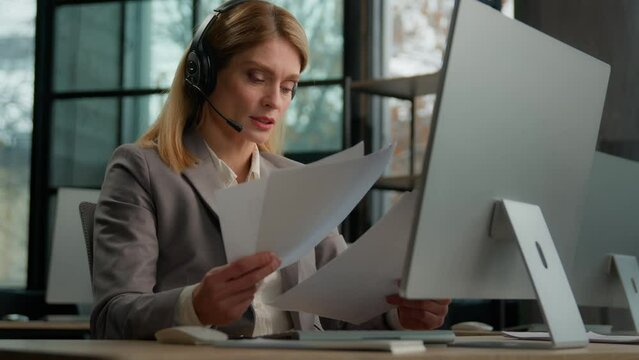 Call center female worker woman customer support service manager operator Caucasian businesswoman business coach with documents papers talking with headset video call conference check report paperwork