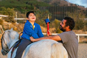 Handicapped boy laughing during an equine therapy session