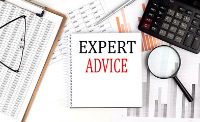 EXPERT ADVICE text on notebook with clipboard and calculator on a chart background