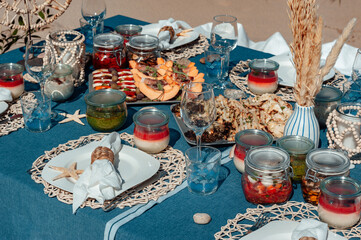 Beautiful table setting with plate, white napkin, braided decorative ring and starfish. Picnic in the style of boho. Closeup.