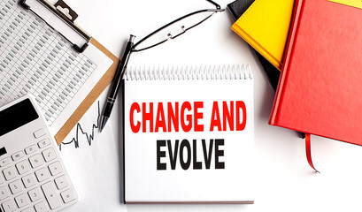 CHANGE AND EVOLVE text on notebook with clipboard and calculator on white background