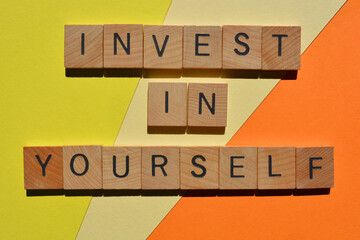 Invest In Yourself, phrase in wooden alphabet letters isolated on colourful background