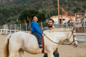 Happy disabled boy having fun during equine therapy