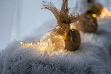 Balls of brown threads on a fluffy carpet with yellow lanterns. Christmas decor.