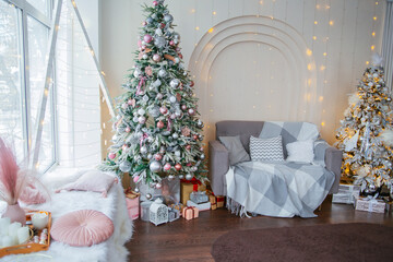 Christmas tree in the interior, pink and white balls with gift boxes.