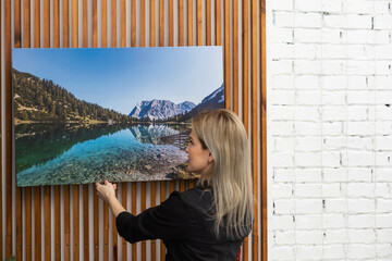 Girl hanging a photo canvas on a wall
