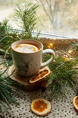 Green tea in a craft cozy cup, dried fruit, orange and cinnamon stick