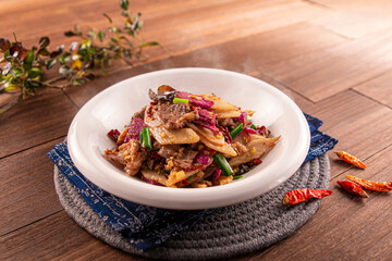 Dry Pot Hunan Style chilli Pork Intestines served dish isolated on wooden table top view of Hong Kong food
