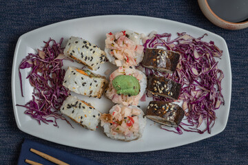 Top view of Sushi pieces with chopsticks with chopsticks and soy.