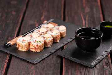 Salmon sushi roll with tuna flakes and souse close-up - sushi asian menu and Japanese food